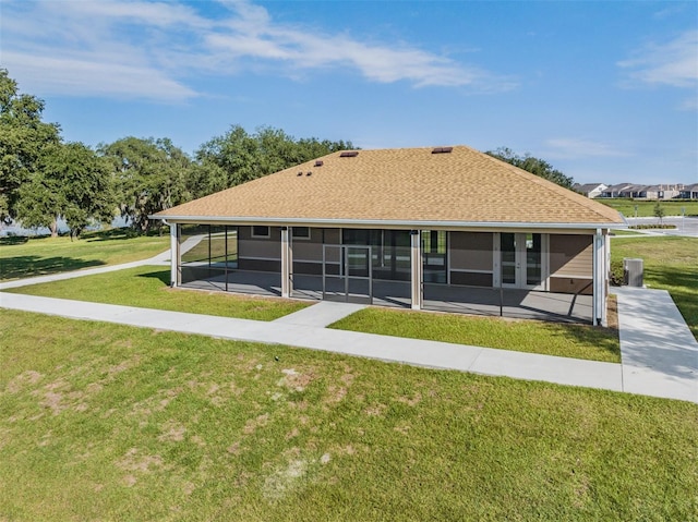 30989 Summer Sun Loop, Wesley Chapel, FL 33545 - rear view of house featuring a sunroom, a lawn, and roof with shingles