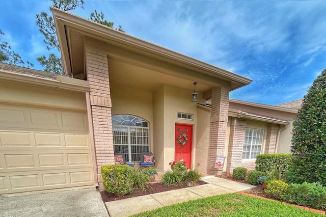 18531 Bent Pine Dr, Hudson, FL 34667 - doorway to property with brick siding, a garage, and stucco siding