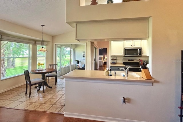 18531 Bent Pine Dr, Hudson, FL 34667 - kitchen featuring appliances with stainless steel finishes, white cabinetry, plenty of natural light, and a peninsula