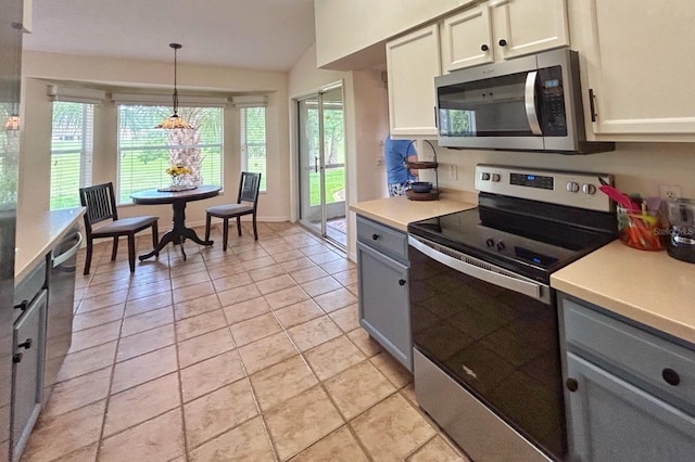18531 Bent Pine Dr, Hudson, FL 34667 - kitchen with appliances with stainless steel finishes, gray cabinets, light countertops, lofted ceiling, and pendant lighting