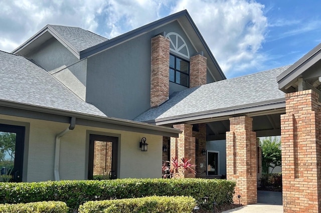 18531 Bent Pine Dr, Hudson, FL 34667 - view of front of home featuring a shingled roof, brick siding, and stucco siding