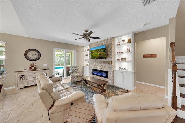 11904 Greenchop Pl, Riverview, FL 33579 - living area featuring a fireplace, a textured ceiling, ceiling fan, light tile patterned floors, and baseboards