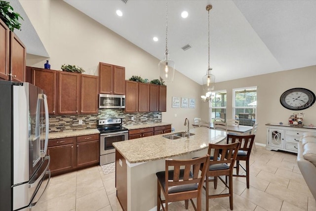 11904 Greenchop Pl, Riverview, FL 33579 - kitchen featuring stainless steel appliances, a sink, backsplash, high vaulted ceiling, and light tile patterned flooring