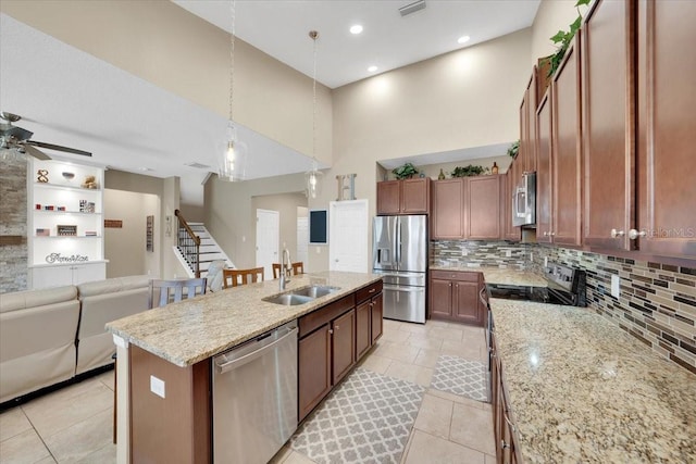 11904 Greenchop Pl, Riverview, FL 33579 - kitchen featuring stainless steel appliances, a sink, open floor plan, a kitchen island with sink, and a high ceiling