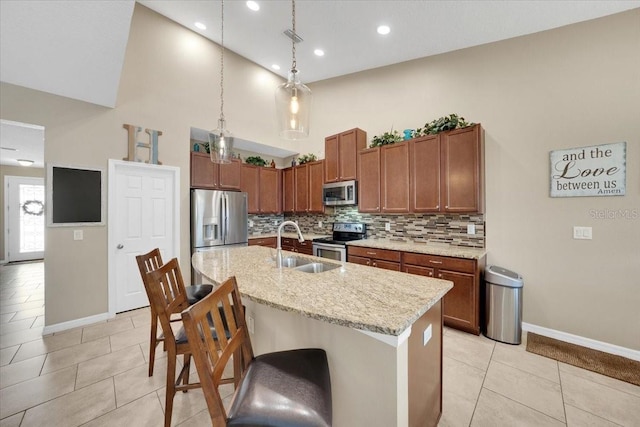 11904 Greenchop Pl, Riverview, FL 33579 - kitchen with appliances with stainless steel finishes, baseboards, a towering ceiling, tasteful backsplash, and a breakfast bar area