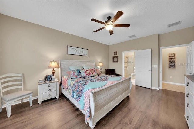 11904 Greenchop Pl, Riverview, FL 33579 - bedroom featuring dark wood-style floors, baseboards, ensuite bathroom, a ceiling fan, and a textured ceiling