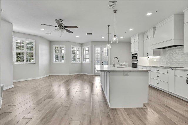 1402 Harbour Walk Rd, Tampa, FL 33602 - kitchen with premium range hood, ceiling fan, stainless steel double oven, light wood-style flooring, and recessed lighting