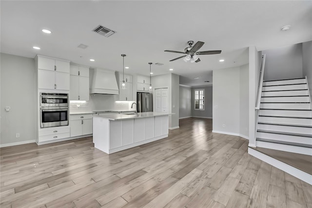 1402 Harbour Walk Rd, Tampa, FL 33602 - kitchen featuring custom range hood, stainless steel appliances, open floor plan, ceiling fan, and baseboards