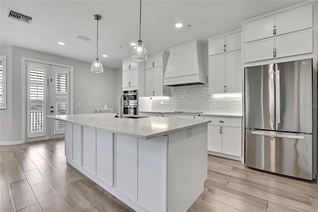1402 Harbour Walk Rd, Tampa, FL 33602 - kitchen with appliances with stainless steel finishes, custom exhaust hood, a sink, white cabinets, and tasteful backsplash