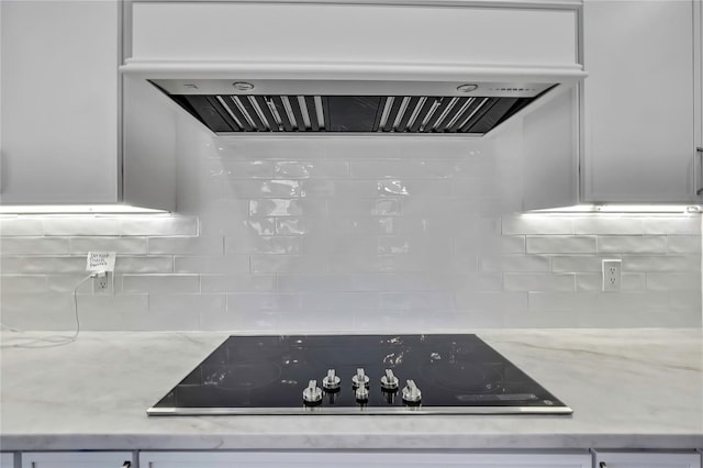 1402 Harbour Walk Rd, Tampa, FL 33602 - kitchen view of range hood, black electric cooktop, tasteful backsplash, light stone countertops, and white cabinets