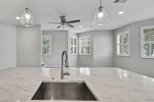 1402 Harbour Walk Rd, Tampa, FL 33602 - kitchen featuring a sink, plenty of natural light, recessed lighting, light stone counters, and decorative light fixtures