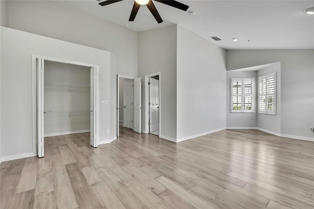 1402 Harbour Walk Rd, Tampa, FL 33602 - unfurnished bedroom with light wood-style flooring, vaulted ceiling, baseboards, a walk in closet, and ceiling fan