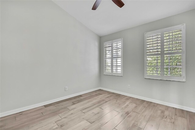 1402 Harbour Walk Rd, Tampa, FL 33602 - empty room with wood finished floors, ceiling fan, baseboards, healthy amount of natural light, and vaulted ceiling