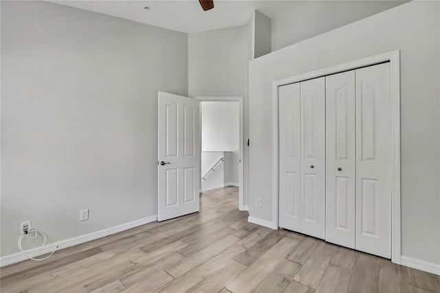 1402 Harbour Walk Rd, Tampa, FL 33602 - unfurnished bedroom featuring light wood finished floors, baseboards, a closet, a high ceiling, and a ceiling fan