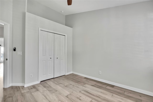 1402 Harbour Walk Rd, Tampa, FL 33602 - unfurnished bedroom featuring light wood-style floors, a closet, baseboards, a ceiling fan, and a towering ceiling