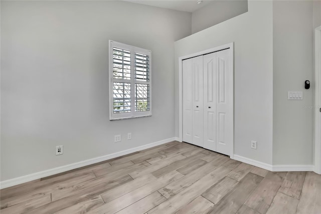 1402 Harbour Walk Rd, Tampa, FL 33602 - unfurnished bedroom with wood finished floors, baseboards, a closet, and a high ceiling