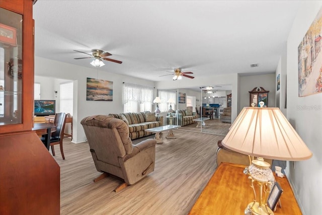 2214 Highclere Cir Unit 6, Sun City Center, FL 33573 - living room with a ceiling fan, light wood finished floors, and baseboards