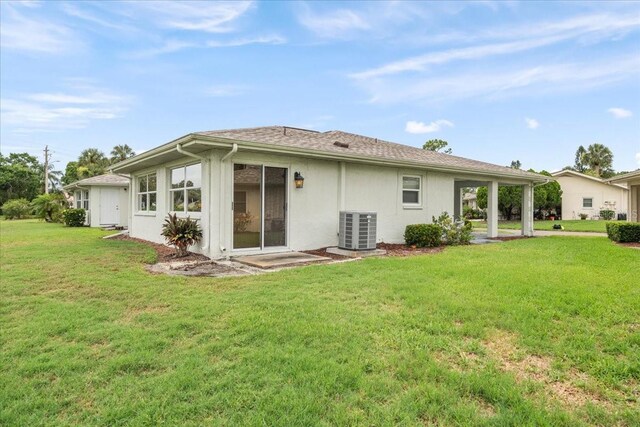 2214 Highclere Cir Unit 6, Sun City Center, FL 33573 - rear view of house with central AC, a lawn, and stucco siding