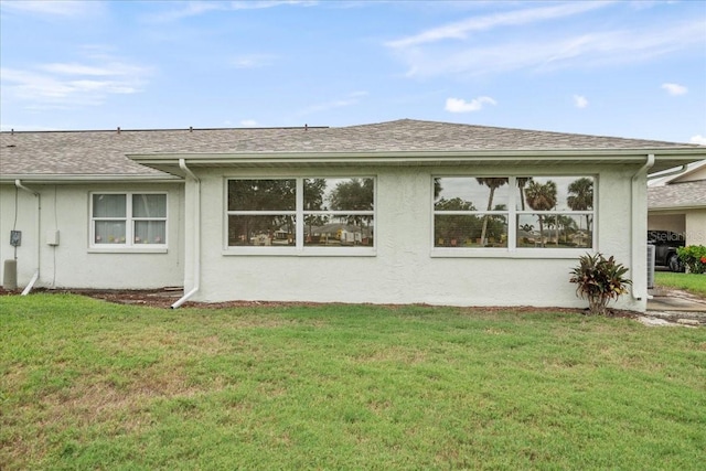 2214 Highclere Cir Unit 6, Sun City Center, FL 33573 - back of property with stucco siding, a yard, and a shingled roof