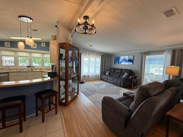 12021 Club House Rd, Brooksville, FL 34613 - living room with lofted ceiling, healthy amount of natural light, a textured ceiling, and light wood-style flooring