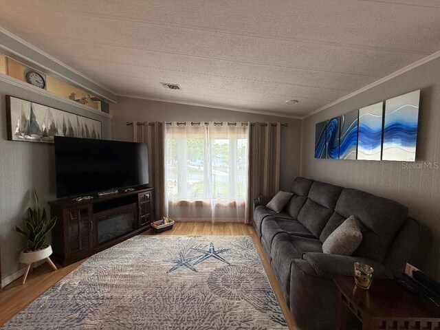 12021 Club House Rd, Brooksville, FL 34613 - living room with crown molding, wood finished floors, lofted ceiling, and a textured ceiling