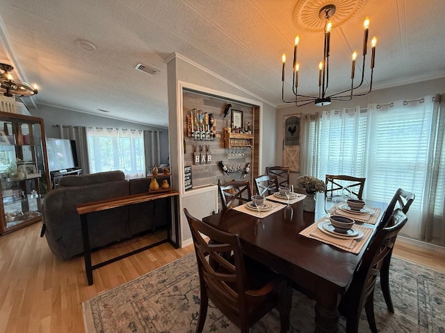 12021 Club House Rd, Brooksville, FL 34613 - dining area featuring lofted ceiling, a chandelier, light wood-type flooring, ornamental molding, and a textured ceiling