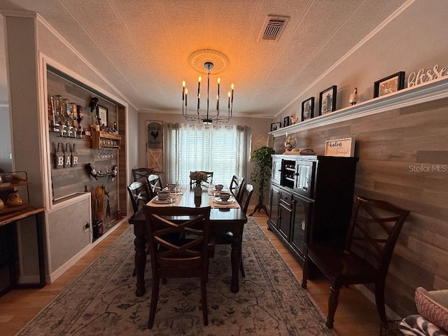 12021 Club House Rd, Brooksville, FL 34613 - dining area featuring crown molding, a chandelier, wood finished floors, and a textured ceiling