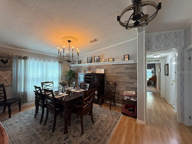12021 Club House Rd, Brooksville, FL 34613 - dining space featuring a chandelier, a textured ceiling, crown molding, and light wood finished floors