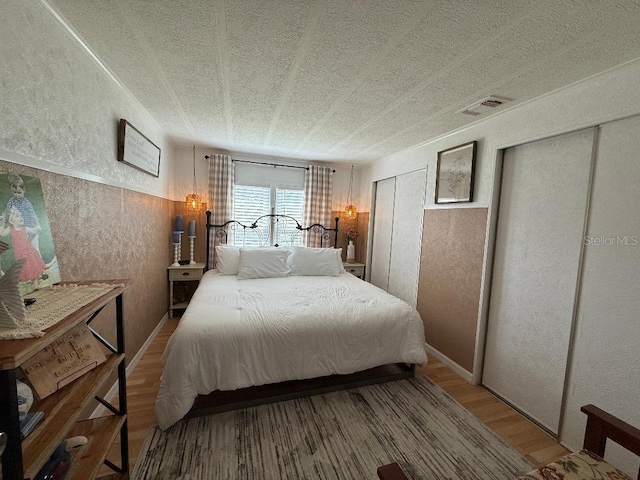 12021 Club House Rd, Brooksville, FL 34613 - bedroom with a textured wall, wood finished floors, and multiple closets