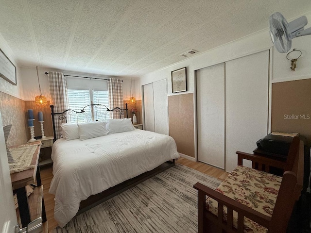12021 Club House Rd, Brooksville, FL 34613 - bedroom featuring wood finished floors, two closets, and a textured ceiling