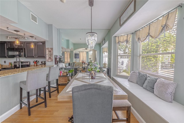 1807 Split Fork Dr, Oldsmar, FL 34677 - living room featuring healthy amount of natural light, light wood-style floors, a chandelier, and baseboards