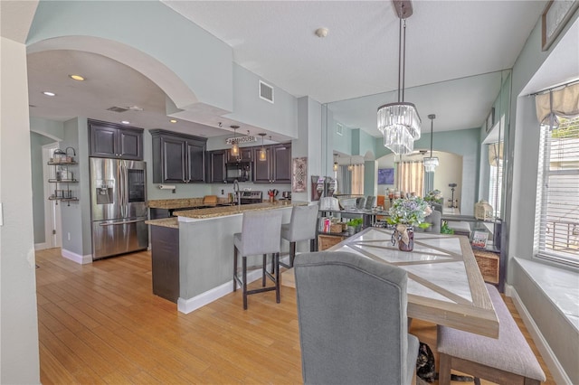 1807 Split Fork Dr, Oldsmar, FL 34677 - dining space featuring a chandelier, baseboards, light wood-type flooring, arched walkways, and recessed lighting