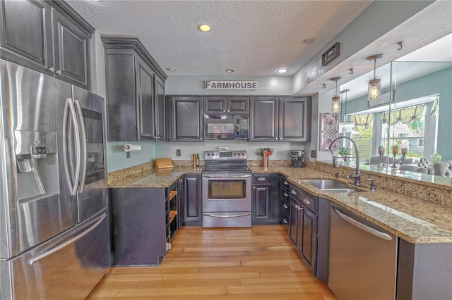 1807 Split Fork Dr, Oldsmar, FL 34677 - kitchen with stainless steel appliances, a sink, a peninsula, a textured ceiling, and light stone countertops