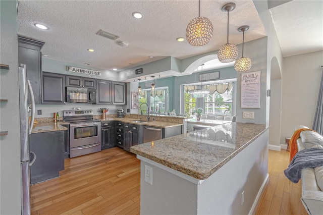 1807 Split Fork Dr, Oldsmar, FL 34677 - kitchen with appliances with stainless steel finishes, arched walkways, a sink, a textured ceiling, and light stone counters