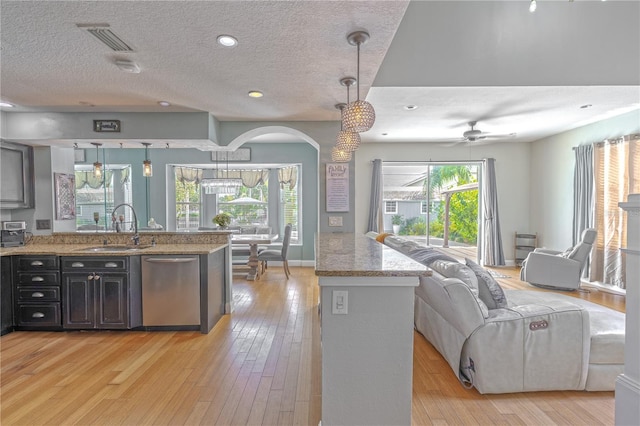 1807 Split Fork Dr, Oldsmar, FL 34677 - kitchen featuring a sink, stainless steel dishwasher, open floor plan, a textured ceiling, and a peninsula