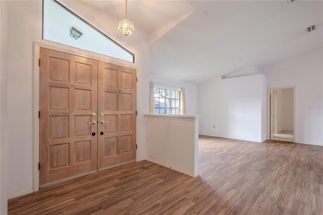 1838 Eagle Ridge Blvd, Palm Harbor, FL 34685 - entrance foyer with vaulted ceiling, wood finished floors, and a chandelier