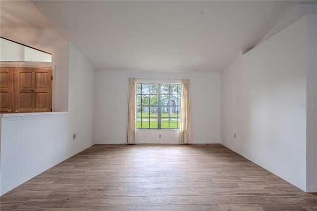 1838 Eagle Ridge Blvd, Palm Harbor, FL 34685 - spare room featuring wood finished floors and vaulted ceiling