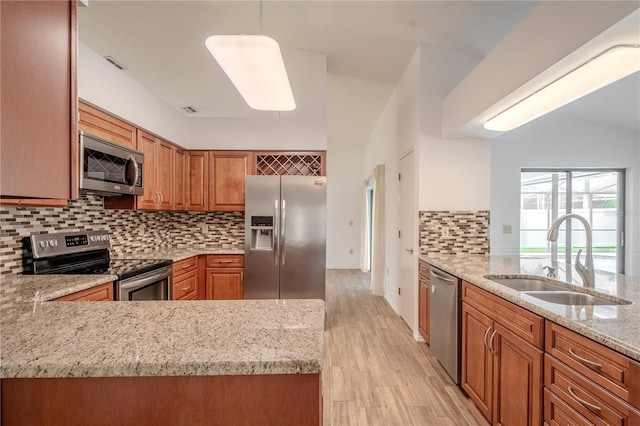 1838 Eagle Ridge Blvd, Palm Harbor, FL 34685 - kitchen featuring stainless steel appliances, brown cabinets, light stone countertops, decorative backsplash, and a peninsula