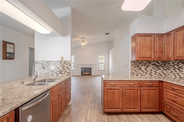 1838 Eagle Ridge Blvd, Palm Harbor, FL 34685 - kitchen featuring stainless steel dishwasher, a ceiling fan, brown cabinetry, light stone counters, and light wood finished floors