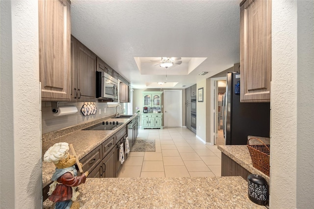 8225 SW 108th Street Rd, Ocala, FL 34481 - kitchen featuring black appliances, light tile patterned flooring, a ceiling fan, a sink, and a tray ceiling