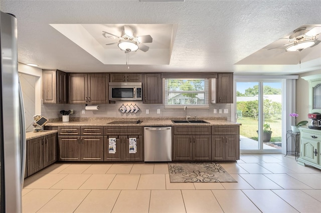 8225 SW 108th Street Rd, Ocala, FL 34481 - kitchen featuring appliances with stainless steel finishes, ceiling fan, a sink, a tray ceiling, and a textured ceiling