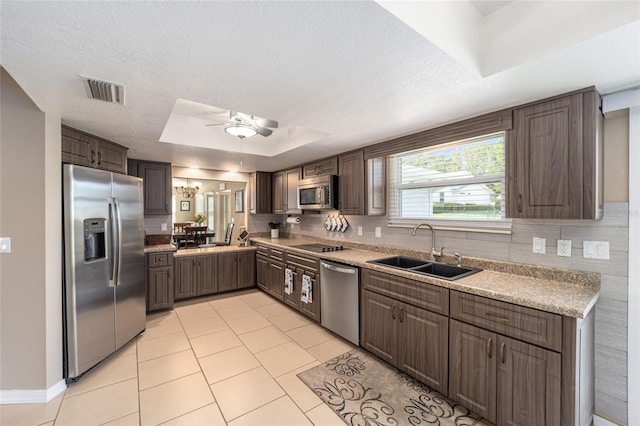 8225 SW 108th Street Rd, Ocala, FL 34481 - kitchen featuring stainless steel appliances, a sink, light tile patterned floors, light countertops, and a tray ceiling