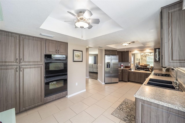 8225 SW 108th Street Rd, Ocala, FL 34481 - kitchen with stainless steel appliances, a raised ceiling, a sink, light tile patterned floors, and a ceiling fan