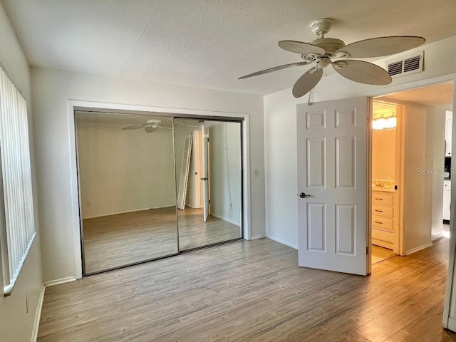 4611 W N B St Unit 125, Tampa, FL 33609 - unfurnished bedroom featuring a closet, light wood-type flooring, baseboards, and a ceiling fan