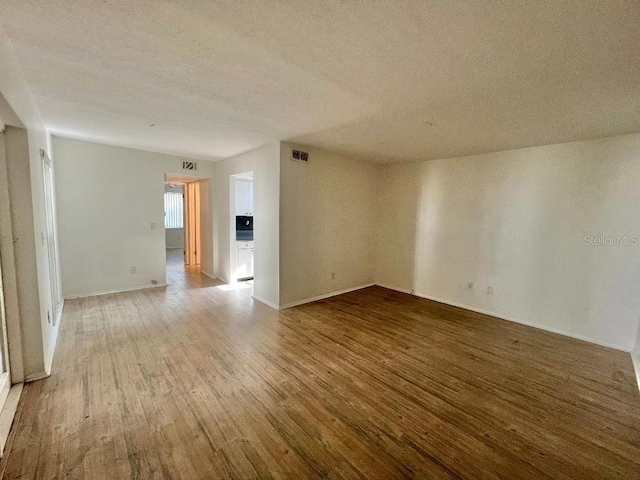 4611 W N B St Unit 125, Tampa, FL 33609 - spare room with wood finished floors, a textured ceiling, and baseboards
