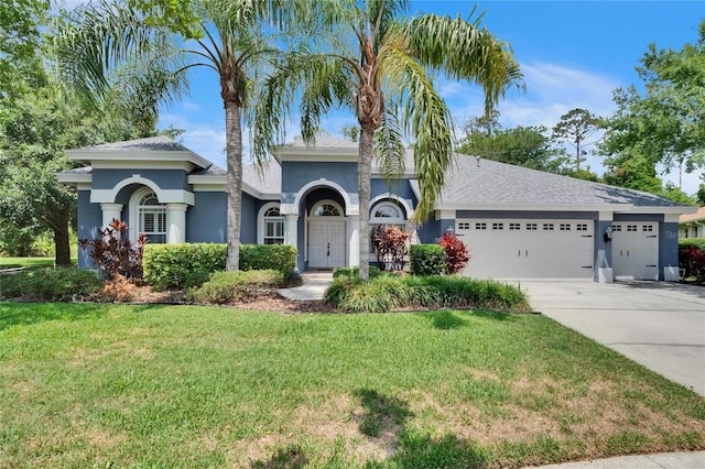 27440 Cedar Park Ct, Wesley Chapel, FL 33544 - view of front of property featuring an attached garage, concrete driveway, a front yard, and stucco siding