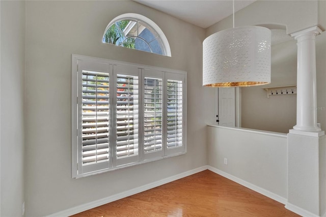 27440 Cedar Park Ct, Wesley Chapel, FL 33544 - empty room with ornate columns, wood finished floors, and baseboards