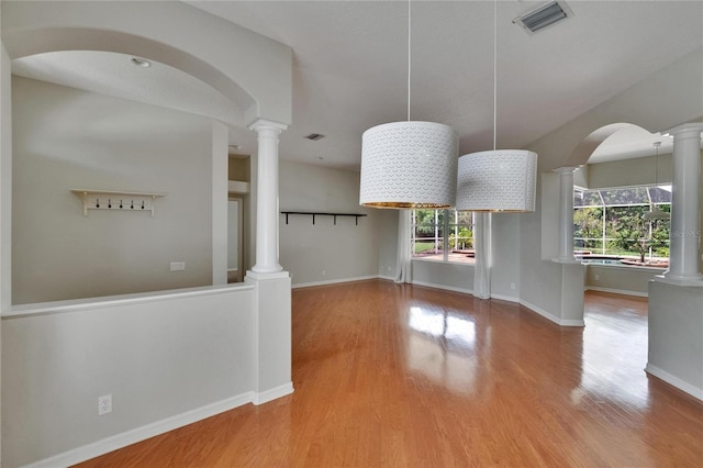 27440 Cedar Park Ct, Wesley Chapel, FL 33544 - unfurnished dining area with wood finished floors, decorative columns, and baseboards