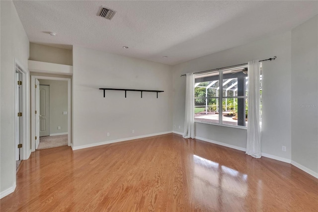 27440 Cedar Park Ct, Wesley Chapel, FL 33544 - empty room featuring light wood-style floors, a textured ceiling, and baseboards