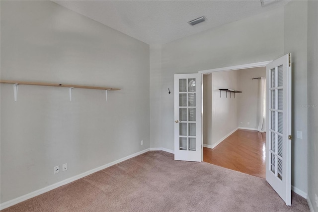 27440 Cedar Park Ct, Wesley Chapel, FL 33544 - carpeted spare room featuring french doors, baseboards, and a textured ceiling